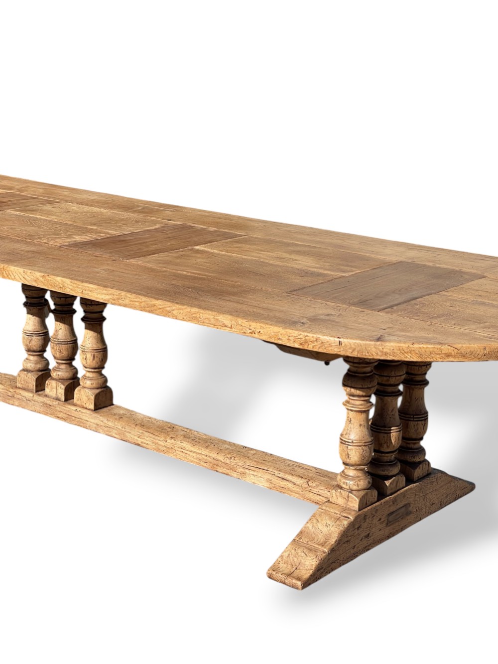 A four-metre French oak refectory dining table with rounded ends, a panelled timber top, and turned baluster legs set on trestle bases. View V