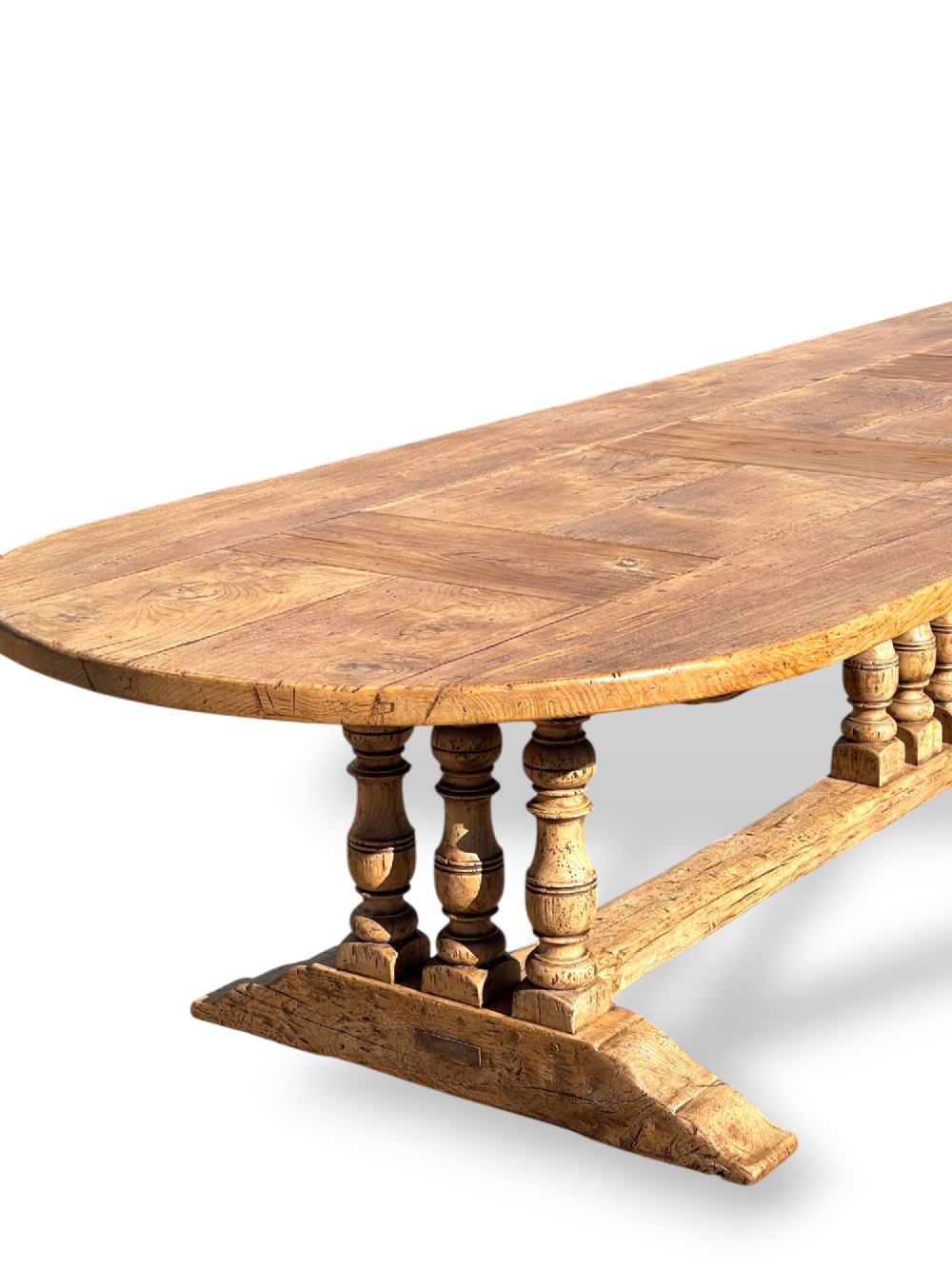 A four-metre French oak refectory dining table with rounded ends, a panelled timber top, and turned baluster legs set on trestle bases. View VIII