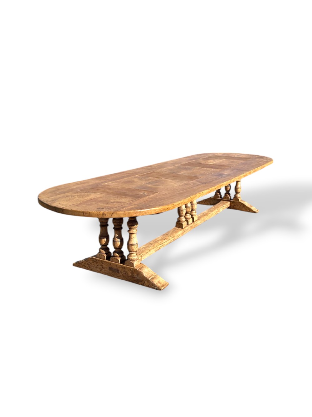 A four-metre French oak refectory dining table with rounded ends, a panelled timber top, and turned baluster legs set on trestle bases. View IX