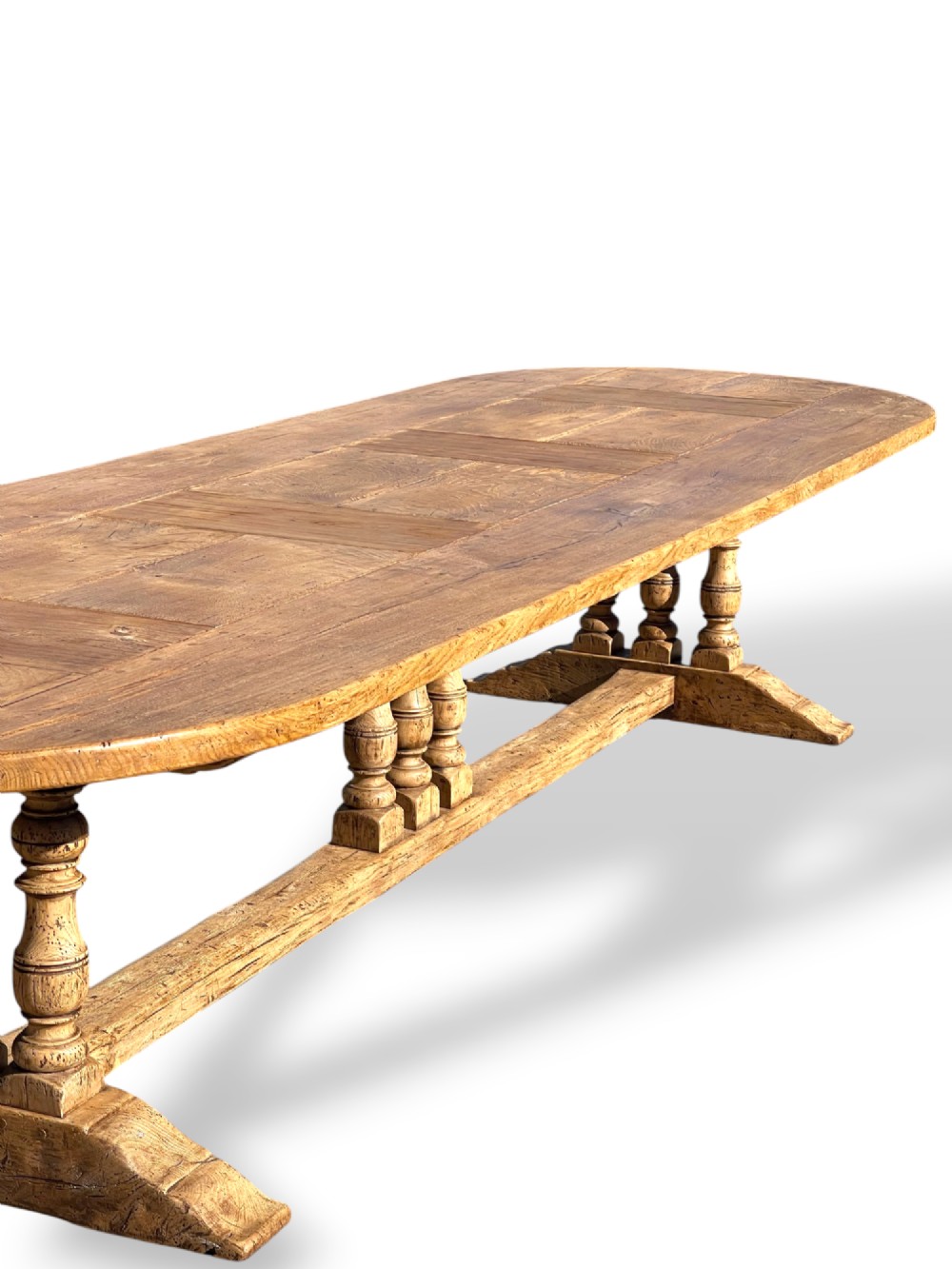 A four-metre French oak refectory dining table with rounded ends, a panelled timber top, and turned baluster legs set on trestle bases. View X