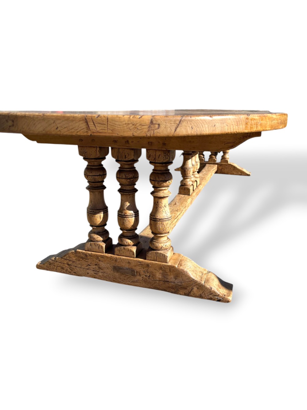 A four-metre French oak refectory dining table with rounded ends, a panelled timber top, and turned baluster legs set on trestle bases. View XI