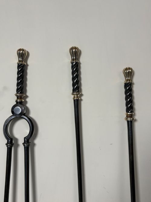 fig 1. A set of three early nineteenth-century dark steel fire tools featuring twisted handles and fluted brass finials.