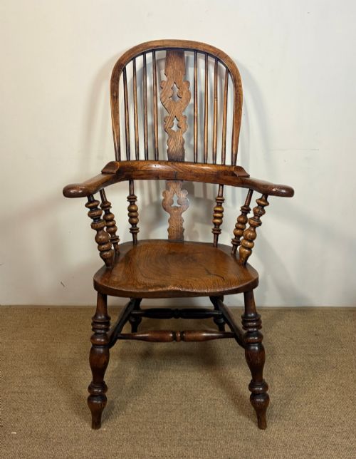 fig 1. A 19th-century high-back wooden Windsor armchair featuring turned legs, a shaped seat, and a pierced back splat with vertical spindles.