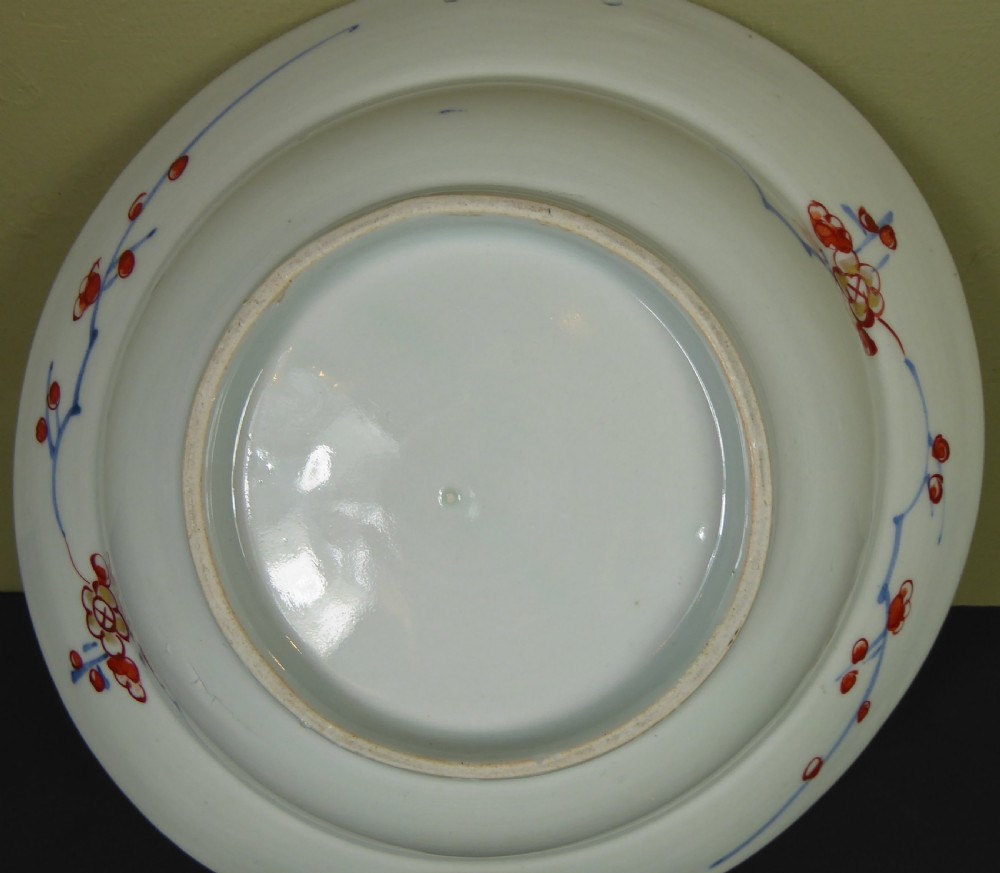 An 18th-century Imari porcelain shaving bowl decorated with hand-painted blue and iron-red floral motifs, featuring a crescent cut-out along the rim. View VII