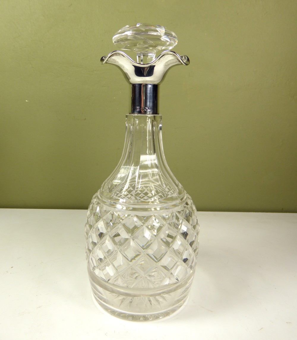 A SILVER MOUNTED CUT GLASS DECANTER
