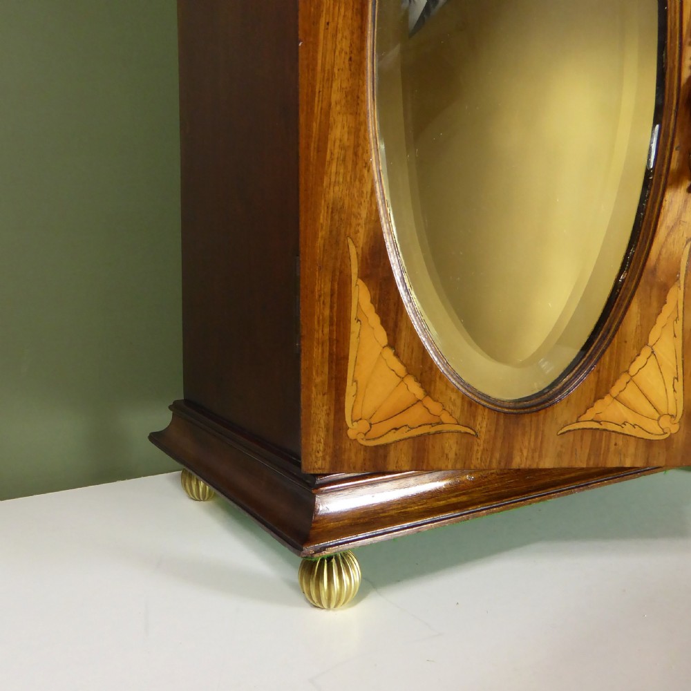 A 19th-century wooden tabletop cabinet featuring oval mirrored double doors, brass handles, brass ball feet, and floral marquetry inlay. View VII