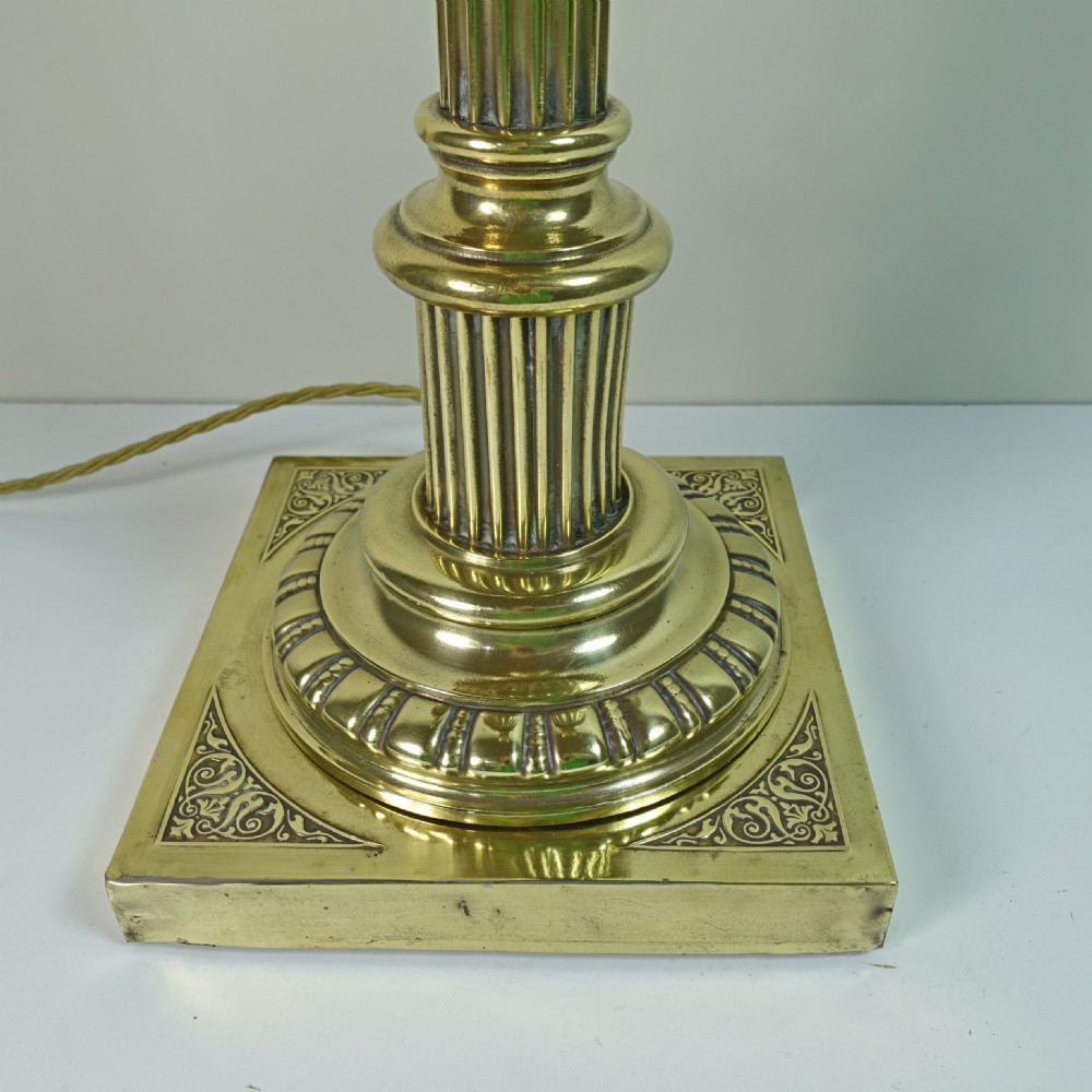 A Victorian brass table lamp base designed in the form of a fluted Corinthian column on a square stepped pedestal. View II