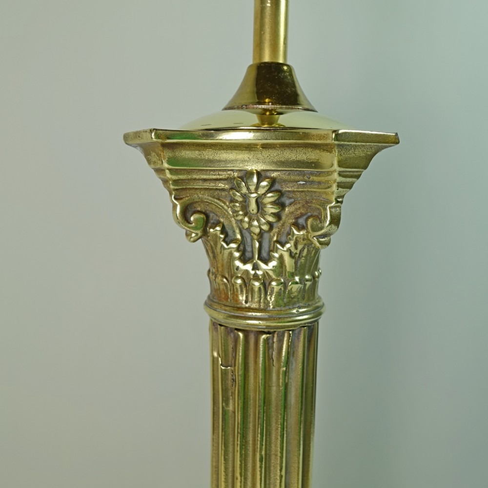 A Victorian brass table lamp base designed in the form of a fluted Corinthian column on a square stepped pedestal. View V
