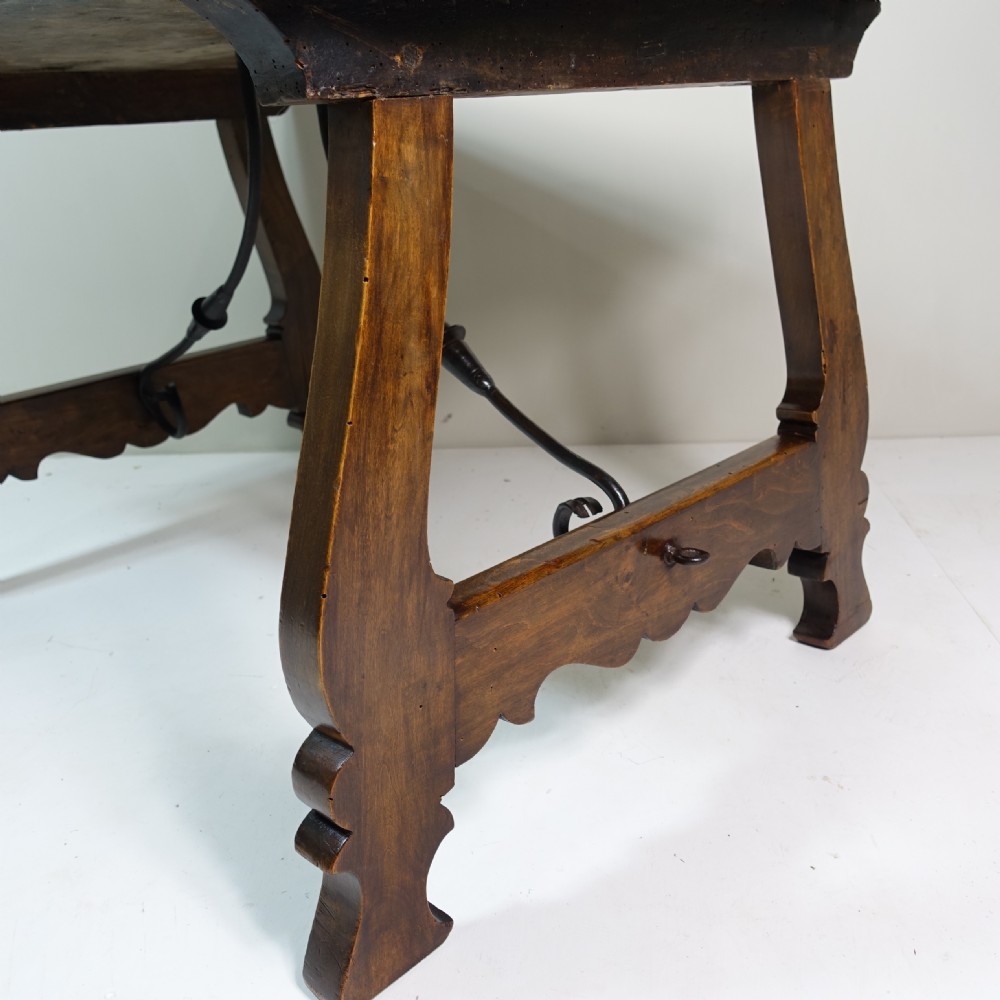 A nineteenth-century dark walnut coffee table featuring splayed trestle legs, carved shaped aprons, and curved wrought iron stretchers. View V
