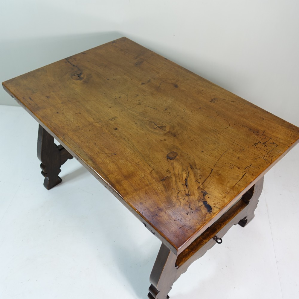 A nineteenth-century dark walnut coffee table featuring splayed trestle legs, carved shaped aprons, and curved wrought iron stretchers. View VI