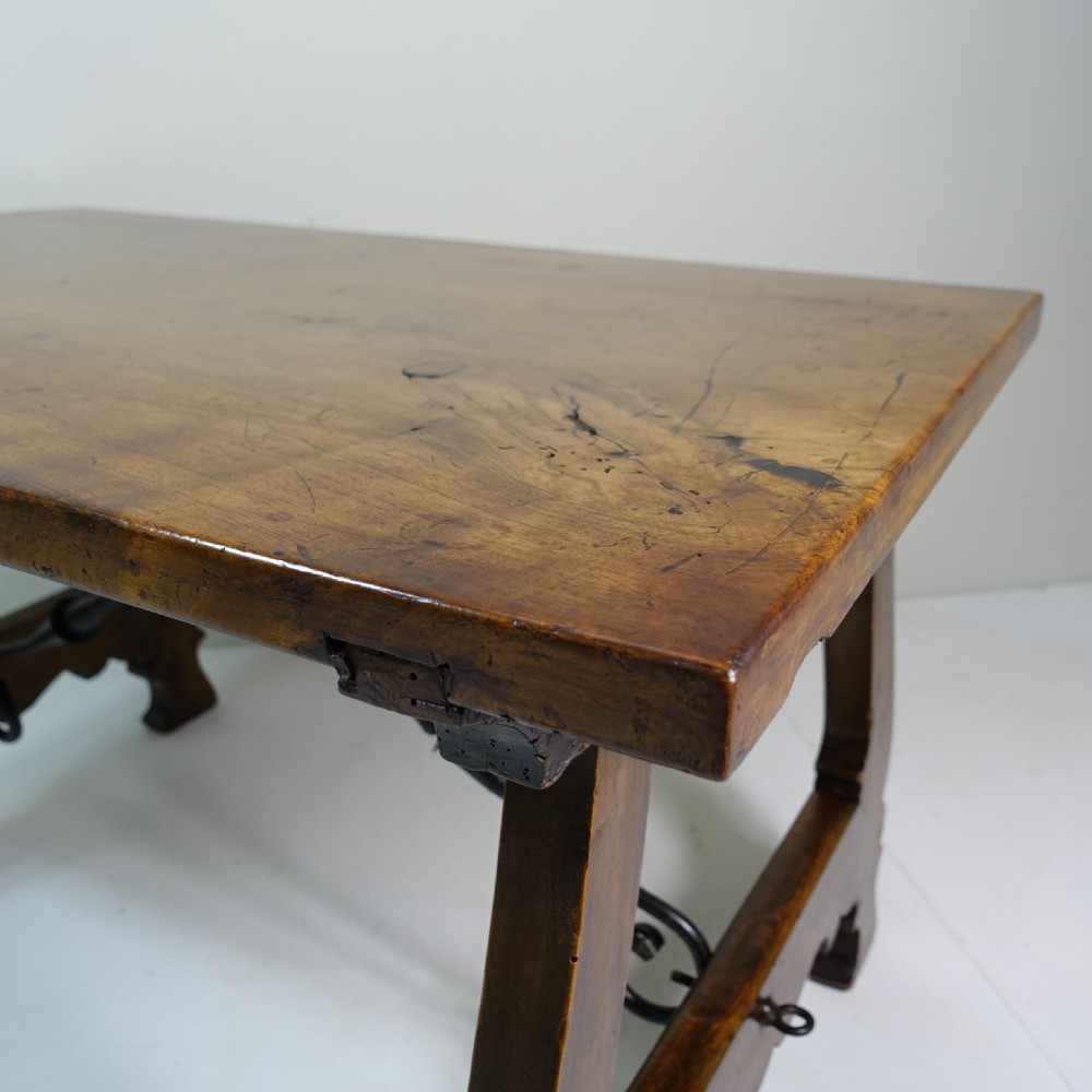 A nineteenth-century dark walnut coffee table featuring splayed trestle legs, carved shaped aprons, and curved wrought iron stretchers. View VII