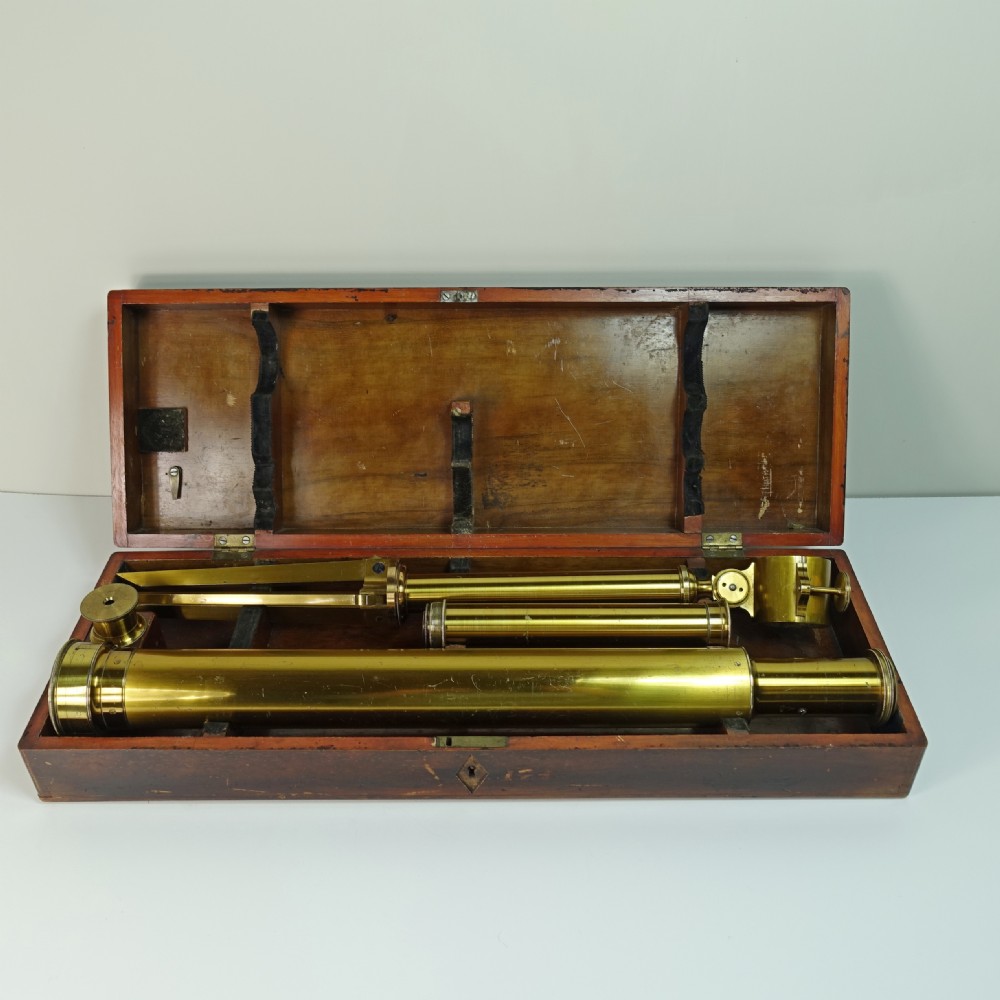 A 19th-century gilt brass tabletop refractor telescope set on a folding tripod stand beside its original wooden fitted box. View III