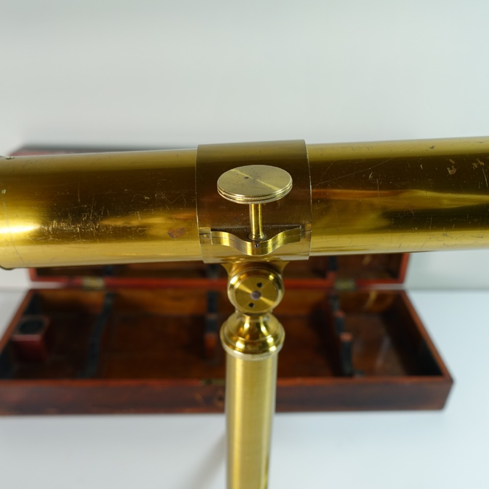 A 19th-century gilt brass tabletop refractor telescope set on a folding tripod stand beside its original wooden fitted box. View VI