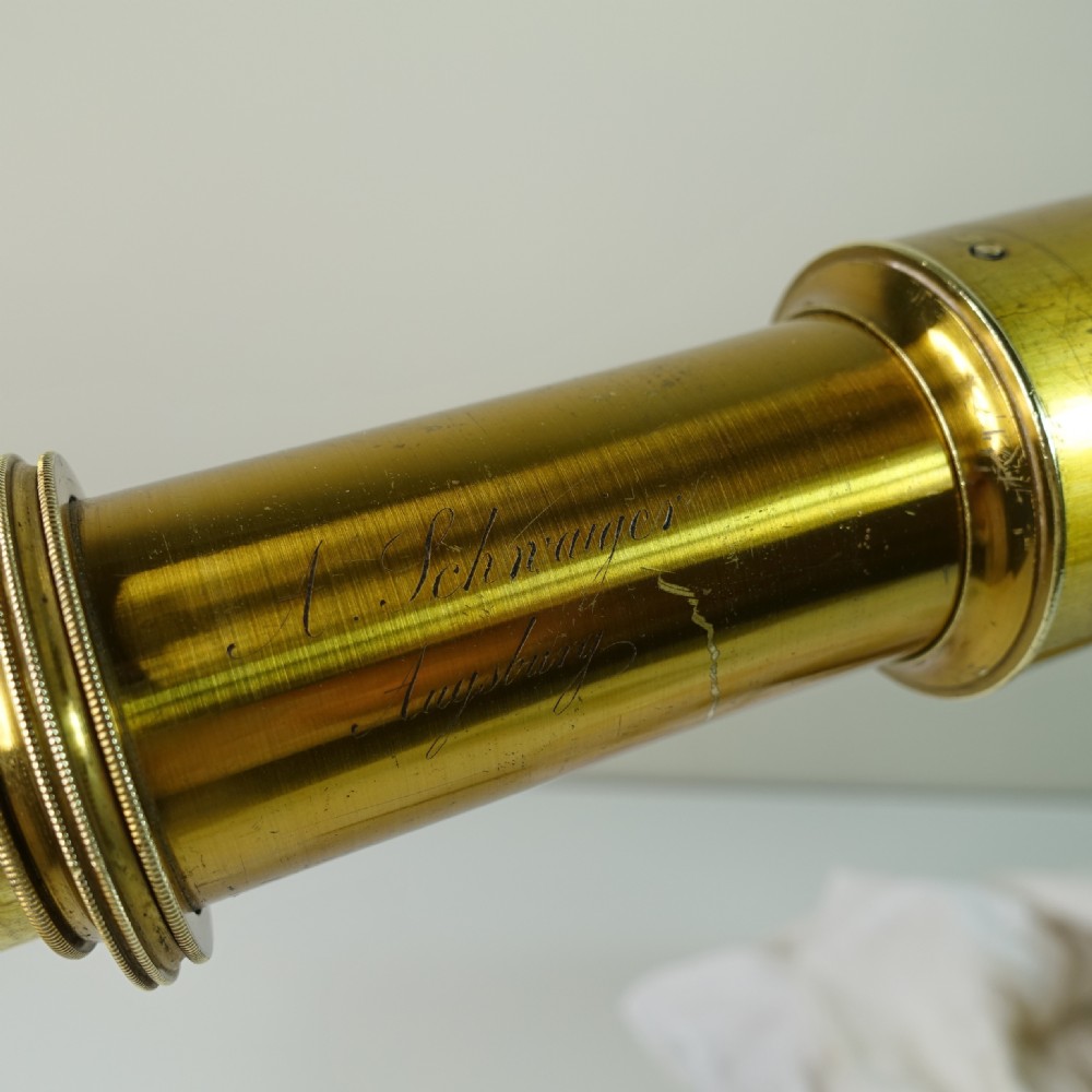 A 19th-century gilt brass tabletop refractor telescope set on a folding tripod stand beside its original wooden fitted box. View VII