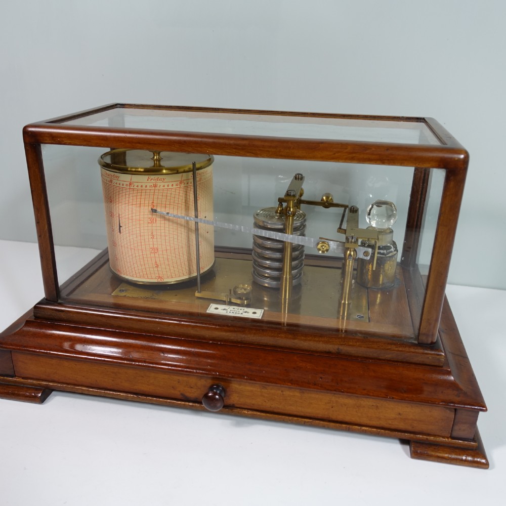 An antique mahogany cased barograph featuring a brass recording mechanism and drum enclosed within a glazed glass display case with a lower drawer. View II