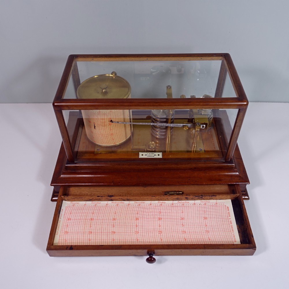 An antique mahogany cased barograph featuring a brass recording mechanism and drum enclosed within a glazed glass display case with a lower drawer. View III