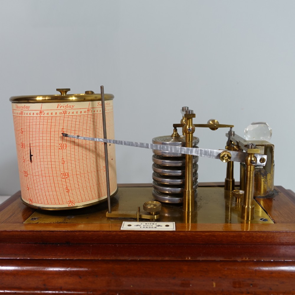 An antique mahogany cased barograph featuring a brass recording mechanism and drum enclosed within a glazed glass display case with a lower drawer. View V