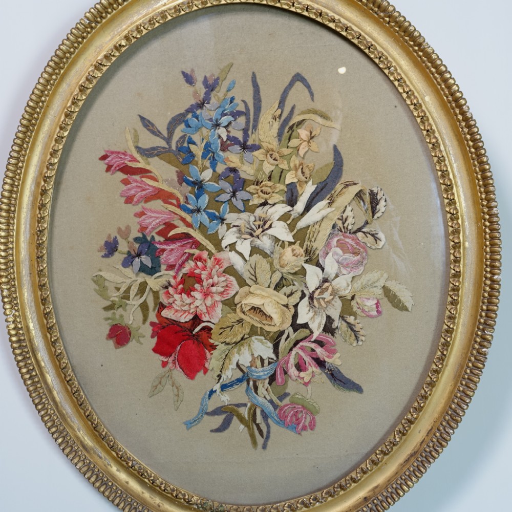 An early nineteenth-century oval gilt-framed textile picture depicting a hand-stitched bouquet of flowers using felt and wool. View II