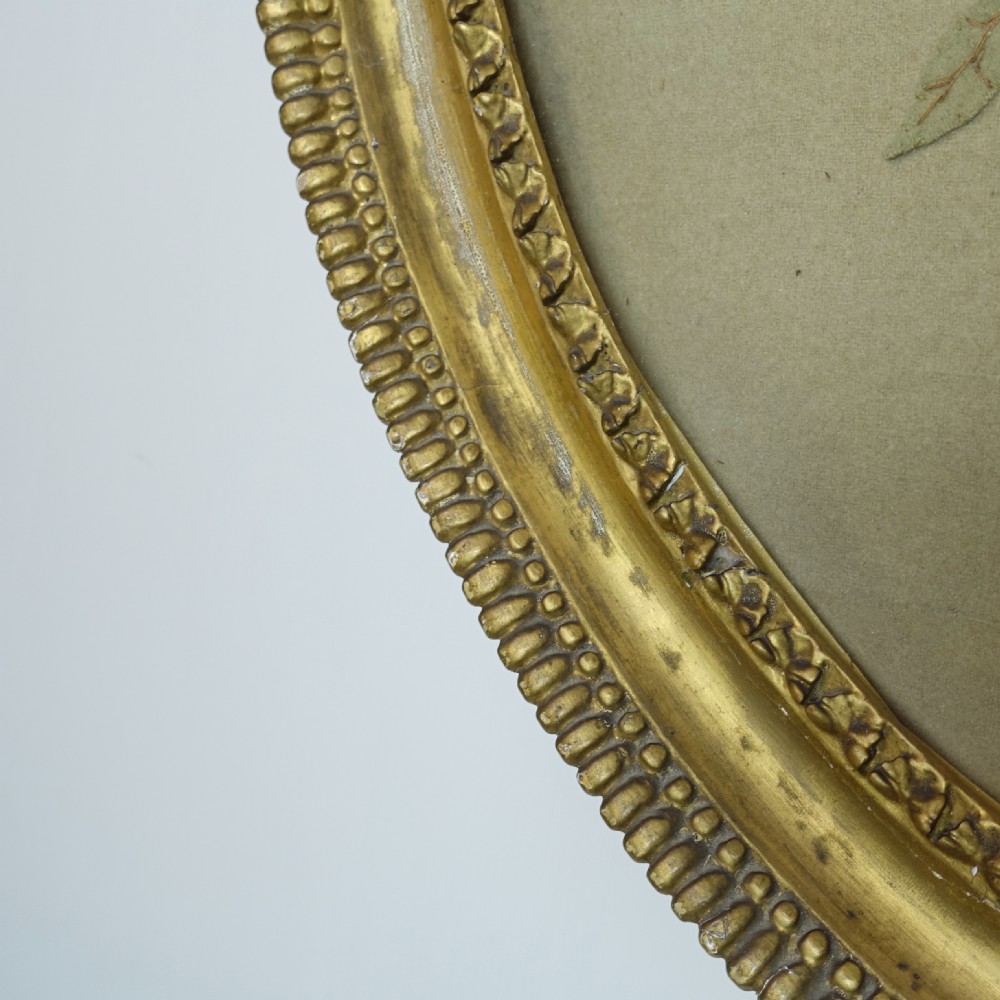 An early nineteenth-century oval gilt-framed textile picture depicting a hand-stitched bouquet of flowers using felt and wool. View IV
