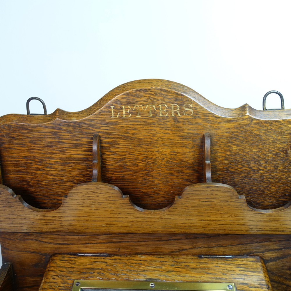 A Victorian carved oak country house letter box featuring tiered racks, carved lettering, a brass aperture slot, and a glass-panelled compartment. View III
