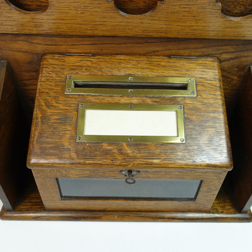 A Victorian carved oak country house letter box featuring tiered racks, carved lettering, a brass aperture slot, and a glass-panelled compartment. View VI
