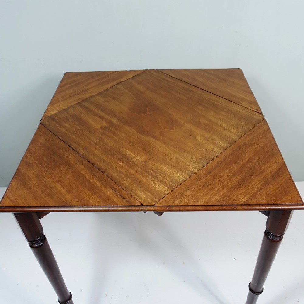 A 19th-century mahogany side table featuring four slender turned legs and triangular hinged drop leaves on each side. View V