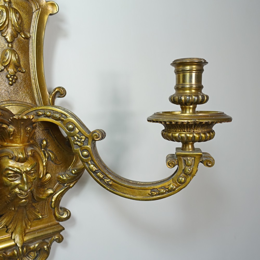 A pair of 19th-century gilt bronze wall sconces, each featuring two scrolling branches, central mascaron face motifs, and shell finials. View IV