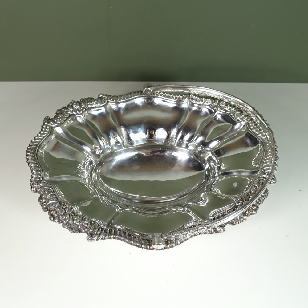 A nineteenth-century silver-plated oval basket featuring fluted side panels, a decorative chased rim, a pedestal base, and an arched swing handle. View III