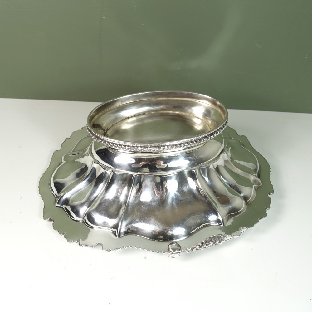 A nineteenth-century silver-plated oval basket featuring fluted side panels, a decorative chased rim, a pedestal base, and an arched swing handle. View VII