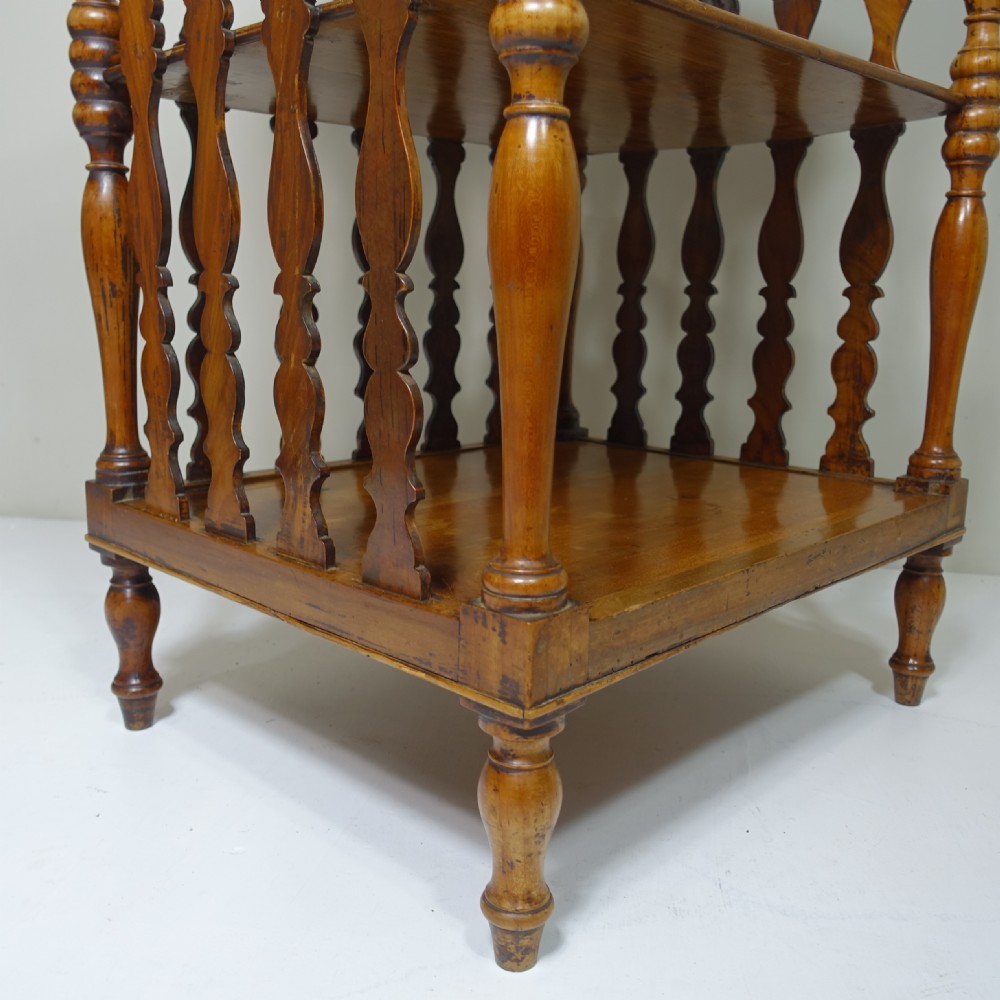 A 19th-century wooden three-tiered whatnot stand featuring turned support columns and shaped vertical splat back panels. View VI
