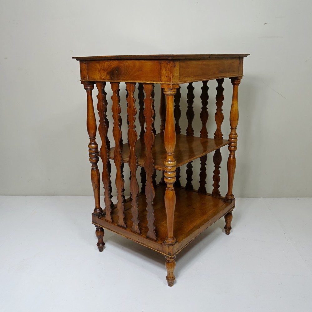A 19th-century wooden three-tiered whatnot stand featuring turned support columns and shaped vertical splat back panels. View VII