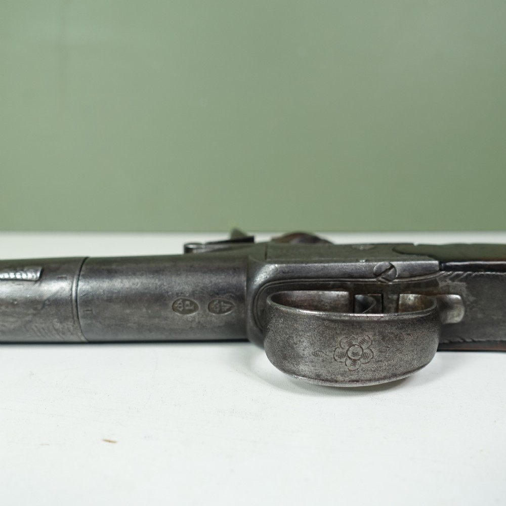 An 18th-century steel box-lock flintlock pistol featuring an engraved lockplate, steel trigger guard, and polished dark walnut grip. View VI