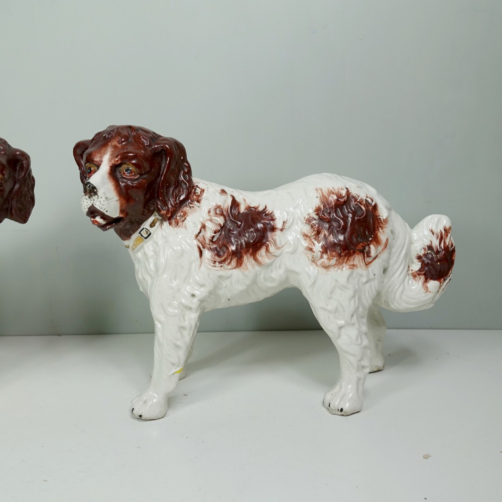 A pair of 19th-century earthenware Staffordshire standing dog figurines with white bodies and hand-painted brown patches. View III