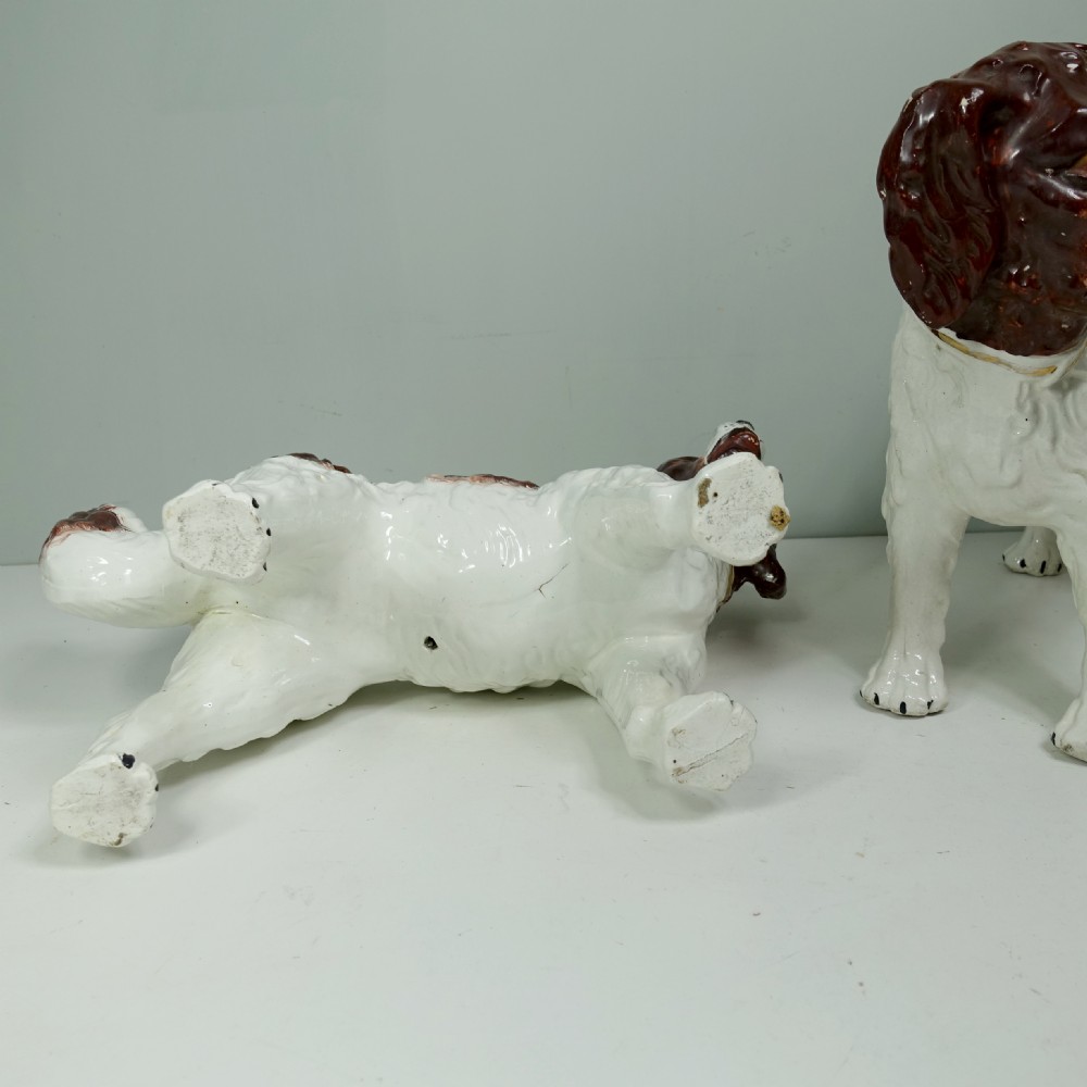 A pair of 19th-century earthenware Staffordshire standing dog figurines with white bodies and hand-painted brown patches. View VI
