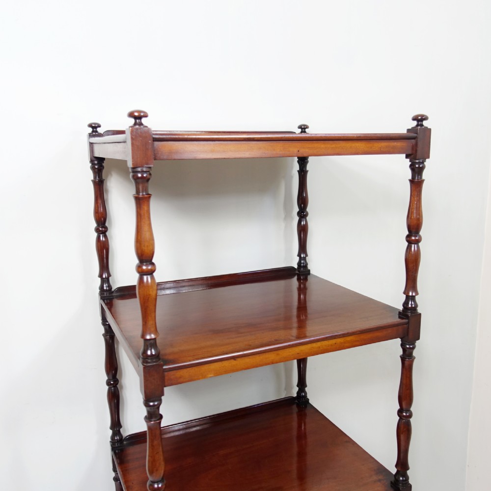 A four-tier Victorian mahogany whatnot featuring turned spindle supports, a single base drawer, and brass castors. View V