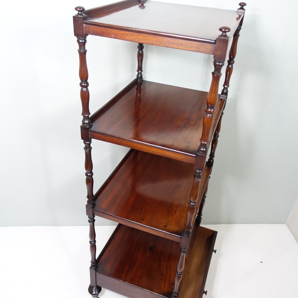 A four-tier Victorian mahogany whatnot featuring turned spindle supports, a single base drawer, and brass castors. View VII