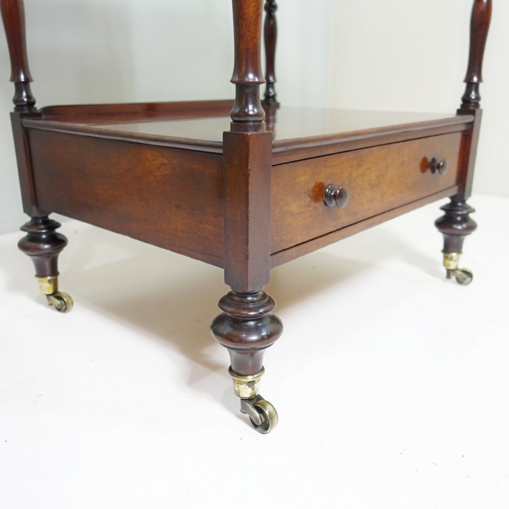 A four-tier Victorian mahogany whatnot featuring turned spindle supports, a single base drawer, and brass castors. View IX