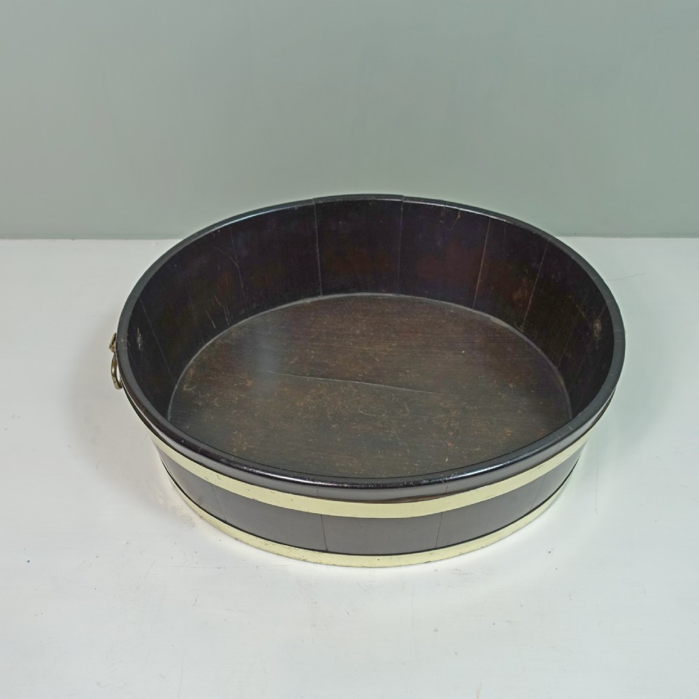 An 18th-century oval mahogany wine cooler featuring coopered wooden staves held together by two wide brass bands and fitted with side brass handles. View IV