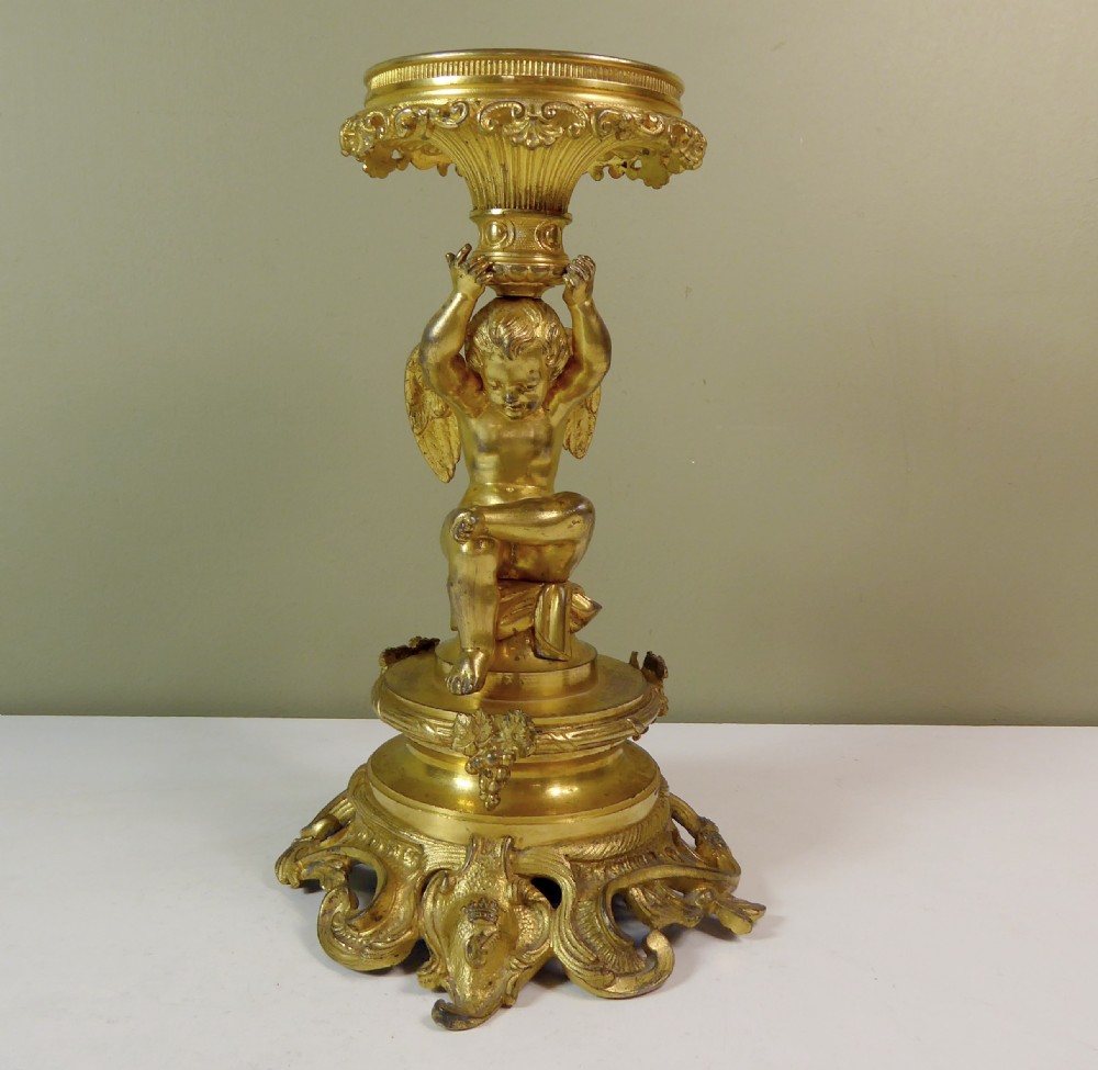 A 19th-century gilt bronze ormolu tazza base featuring a winged cherub figure supporting a fluted capital above a rococo scrolled pedestal. View II