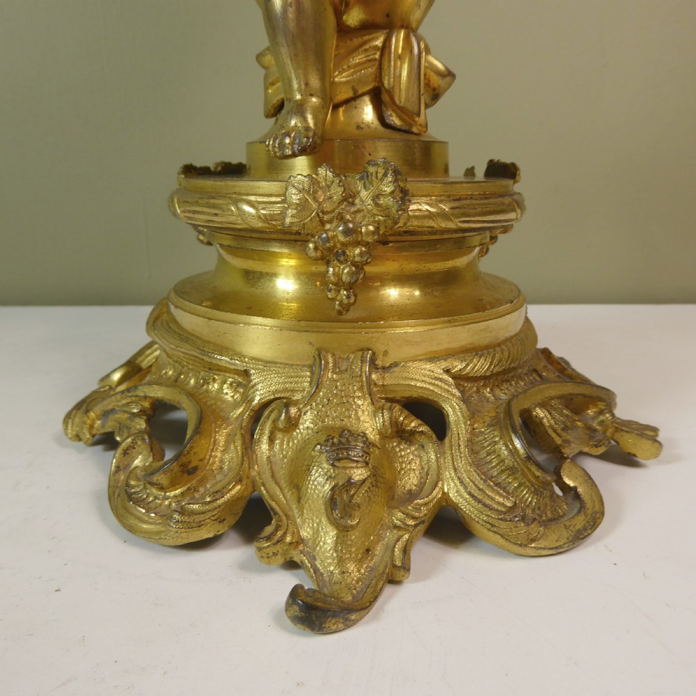 A 19th-century gilt bronze ormolu tazza base featuring a winged cherub figure supporting a fluted capital above a rococo scrolled pedestal. View VI