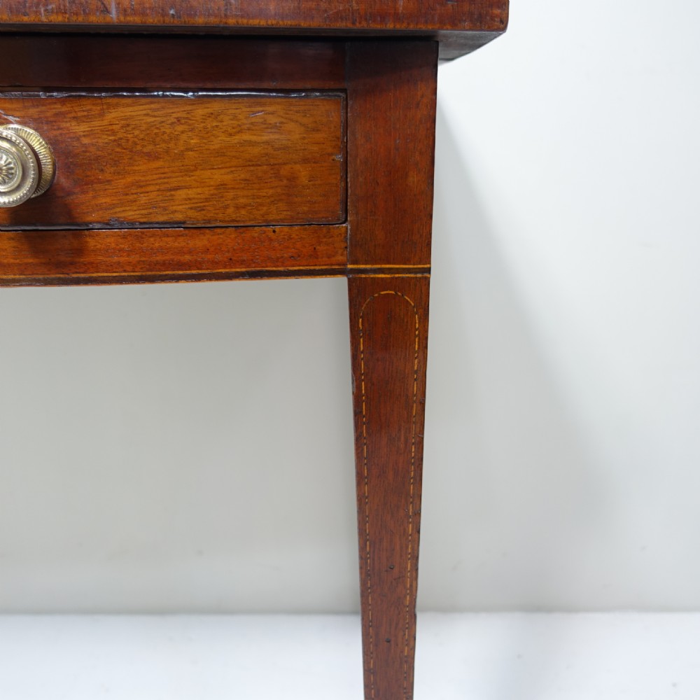 An early 19th-century mahogany side table featuring a single frieze drawer with circular brass handles and tapered legs. View V