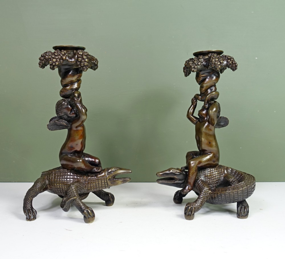 PAIR OF REGENCY BRONZE CANDLESTICKS OF CHERUBS ON CROCODILES