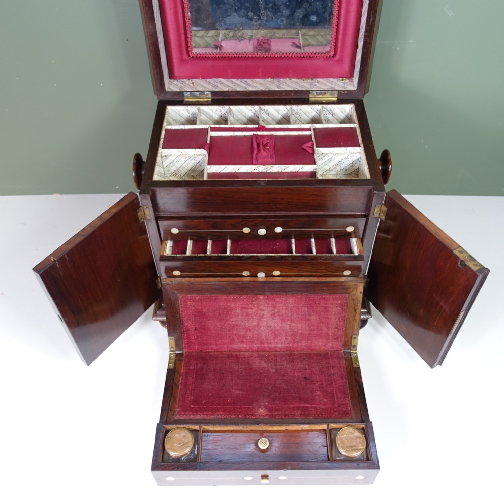 A 19th-century dark rosewood work box featuring floral mother-of-pearl inlay on the front doors and top, set upon turned bun feet. View VI