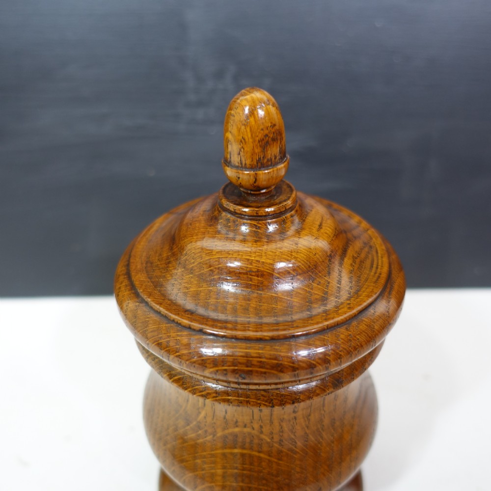A turned 19th-century wooden lidded vase featuring a stepped pedestal base, baluster body, and fitted cover with a acorn finial. View VII