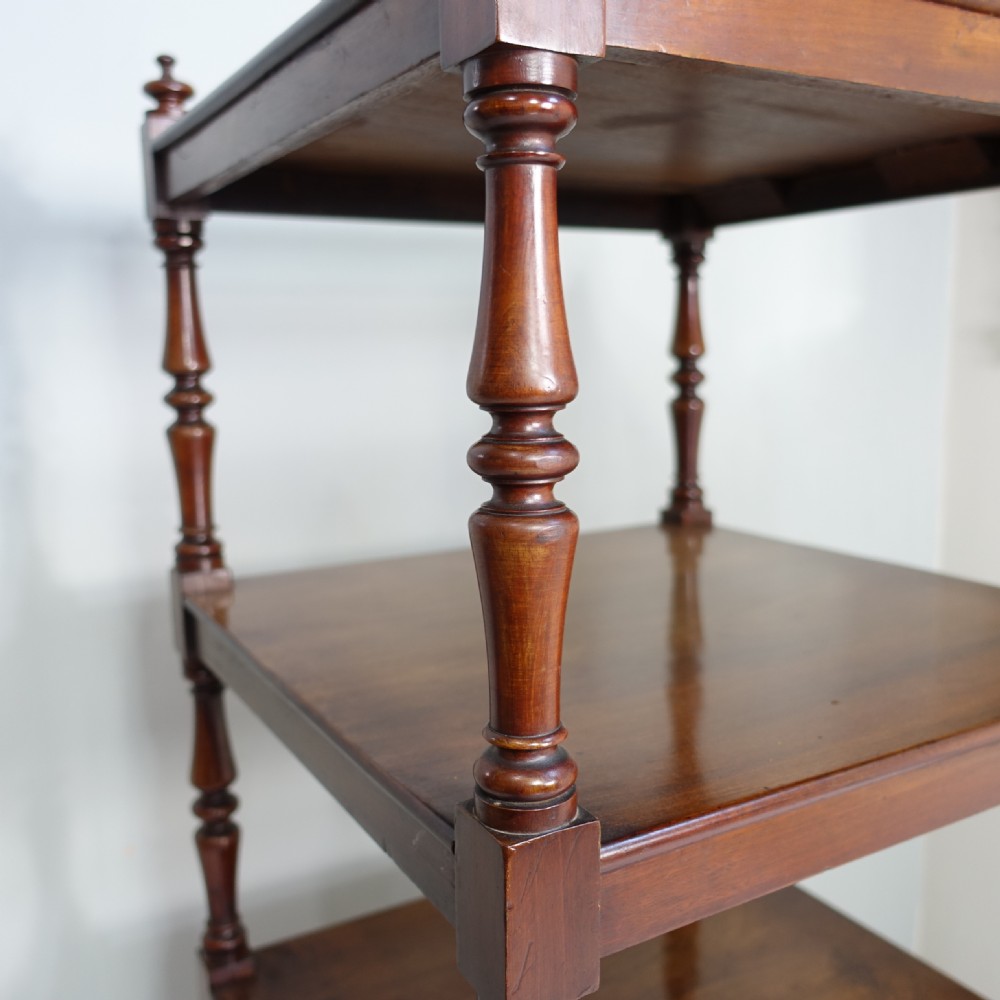 A four-tier mahogany whatnot featuring slender turned spindle supports, top corner finials, and a single drawer at the base with wooden knob handles. View III