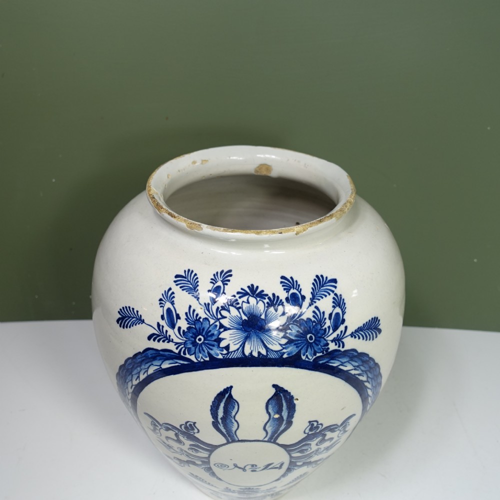An 18th-century blue and white tin-glazed earthenware Delft jar featuring hand-painted floral cartouche decoration numbered No. 14, fitted with a brass lid. View VI