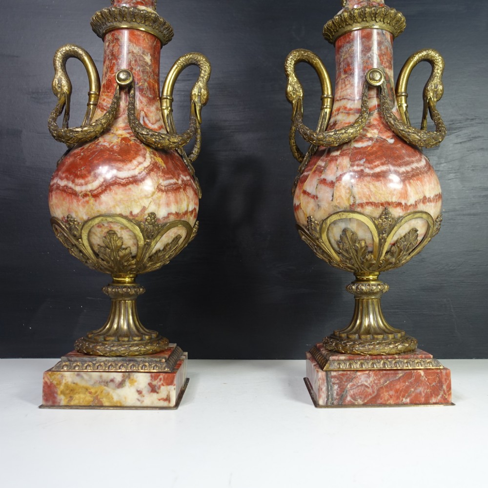 A pair of 19th-century French red veined marble vases with gilded bronze handles and decorative leaf finials set on square plinth bases. View VII