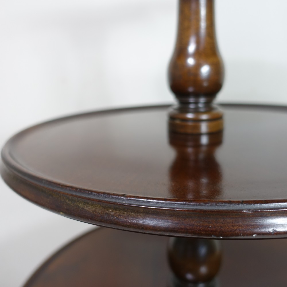 An 18th-century mahogany dumb waiter table featuring three graduated circular tiers supported by turned columns on a tripod base with castors. View V