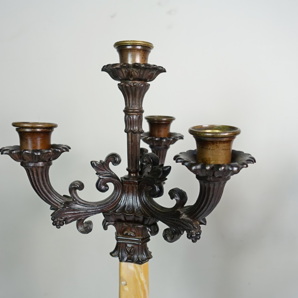A pair of 19th-century patinated bronze five-light candelabra featuring yellow marble shafts and ornate scrollwork bases. View V