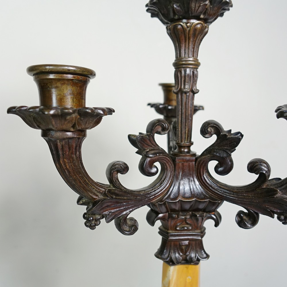 A pair of 19th-century patinated bronze five-light candelabra featuring yellow marble shafts and ornate scrollwork bases. View VIII